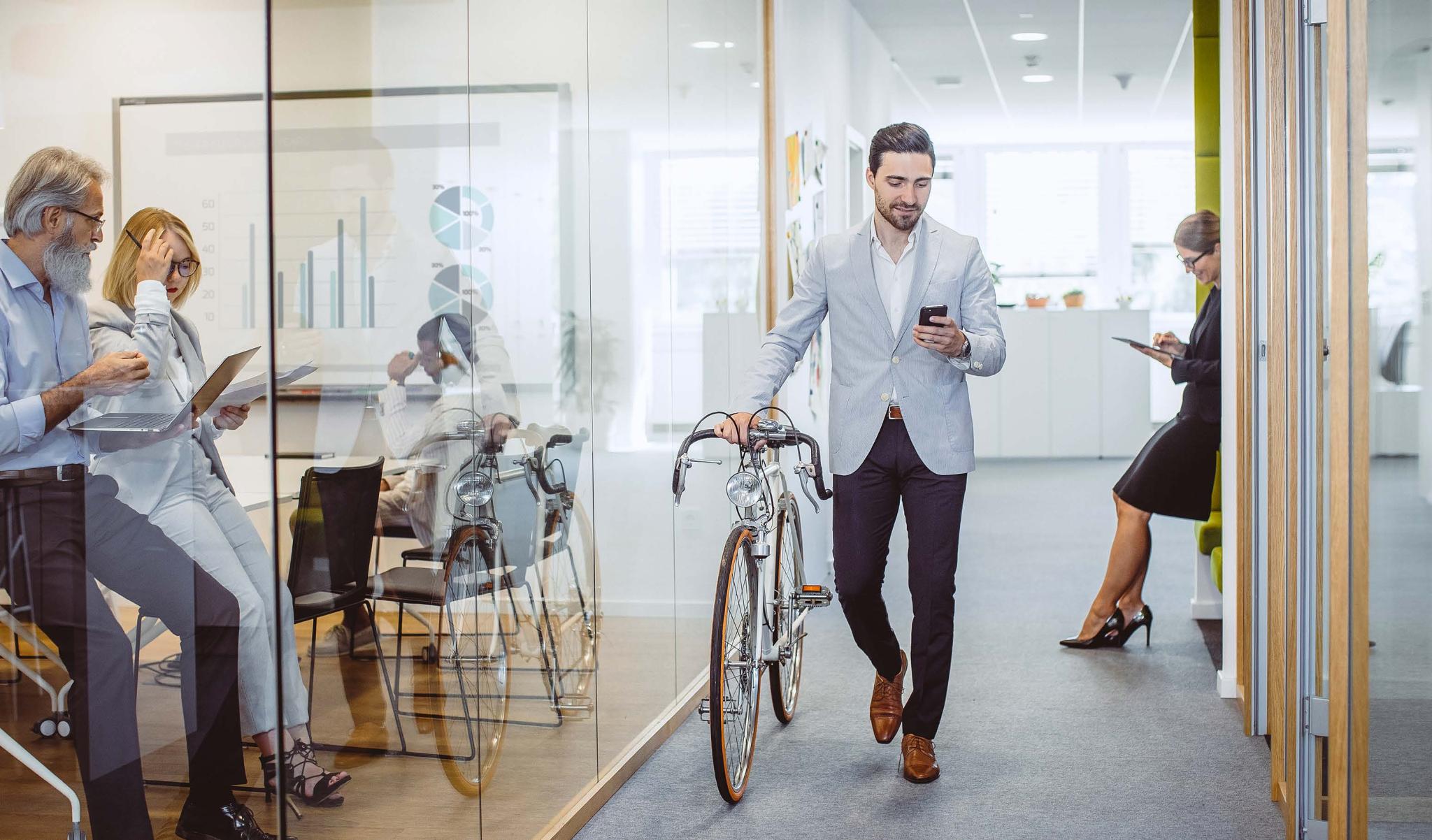 Mann mit Fahrrad im Büro